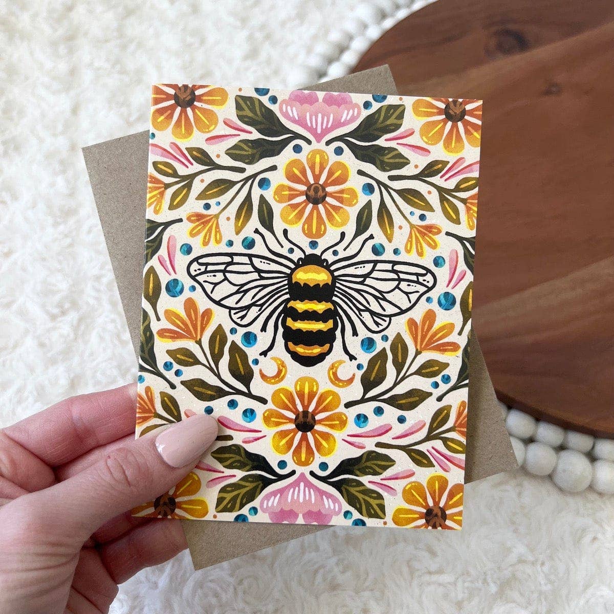 A greeting card hand drawn with a bee and floral design.