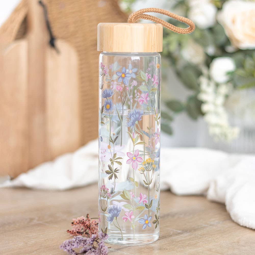 Floral glass water bottle with a bamboo lid and carrying loop.