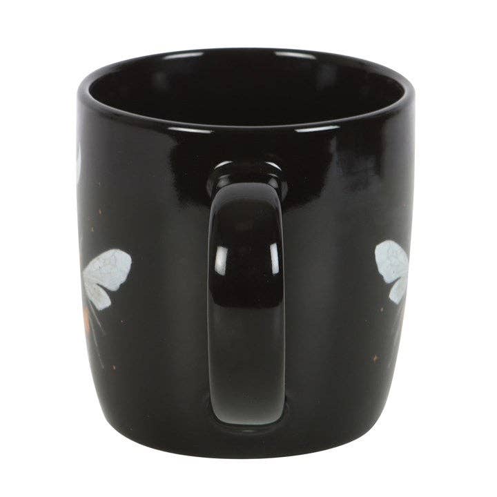 Side view of black mug with forest bee design on both sides.