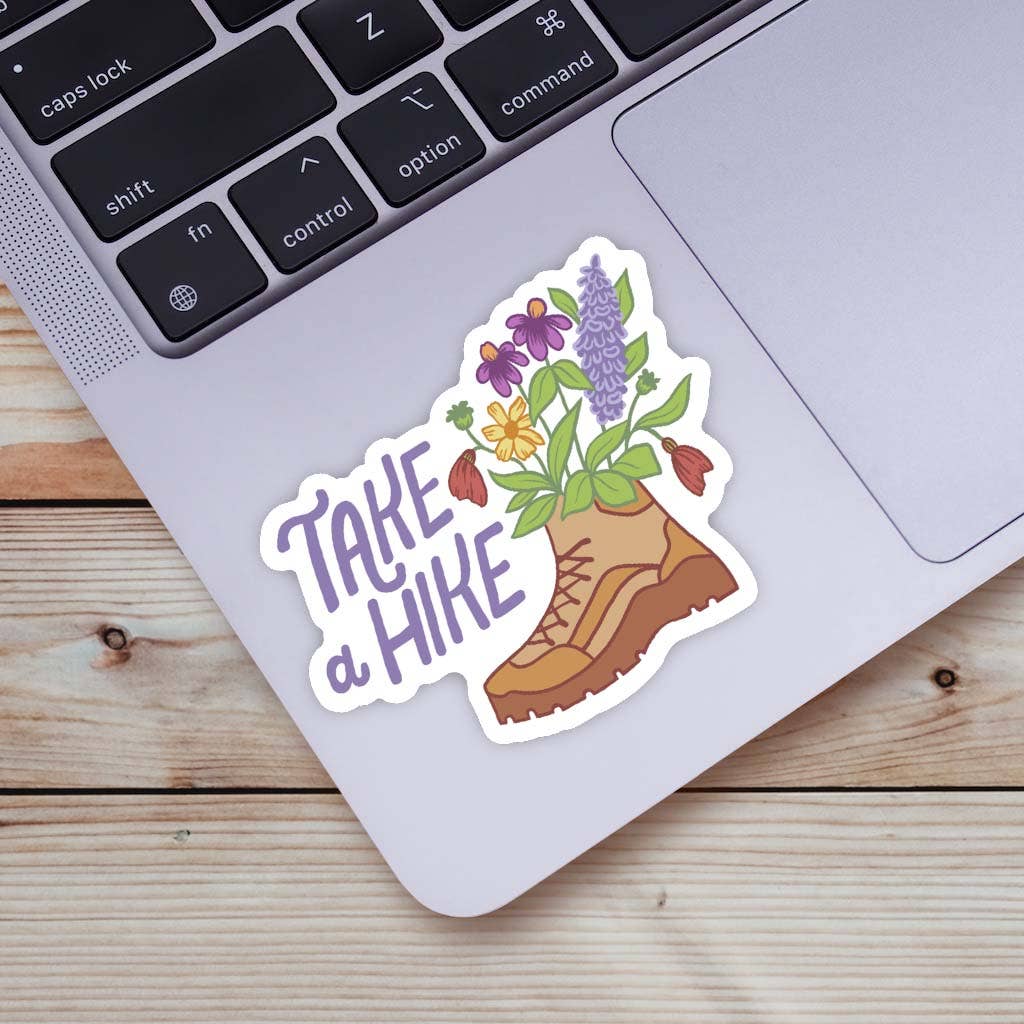 Sticker with flowers sticking out of a boot and the phrase "Take a Hike"