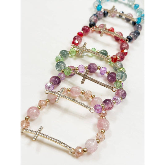 Closeup of rhinestone cross beaded stretch bracelet in pink, purple, green, red, light blue, and navy.
