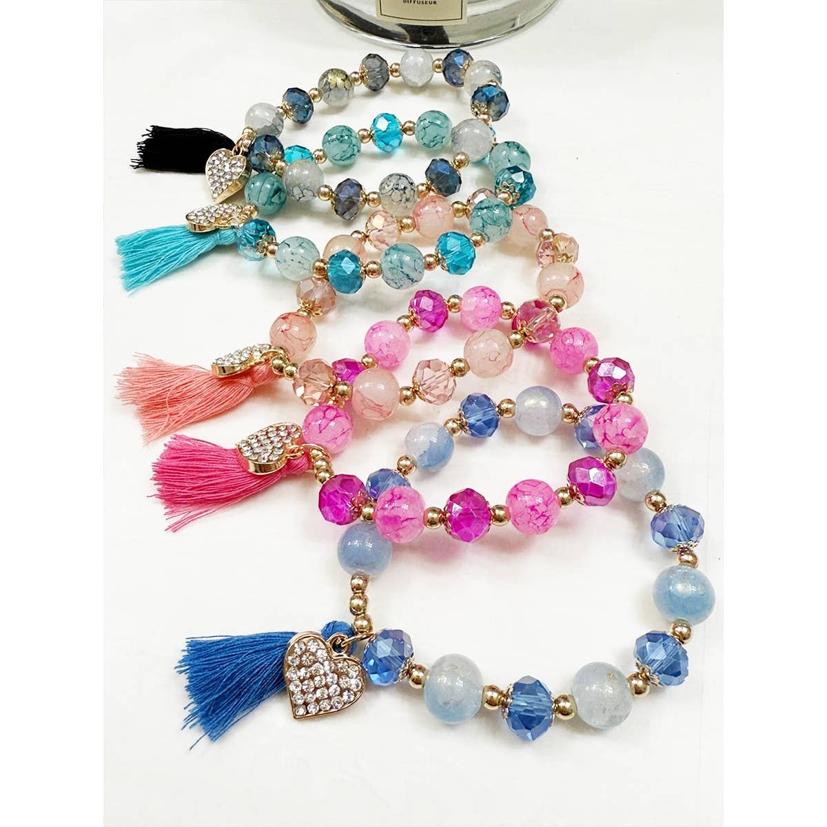 Beaded stretch bracelets with a rhinestone heart and matching tassel.