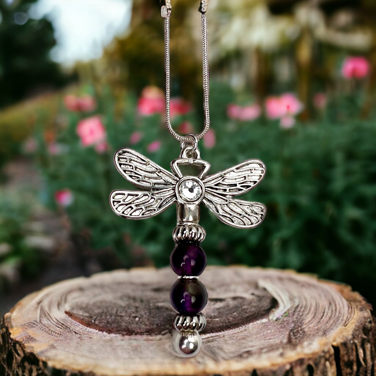 Amethyst dragonfly necklace in a garden setting