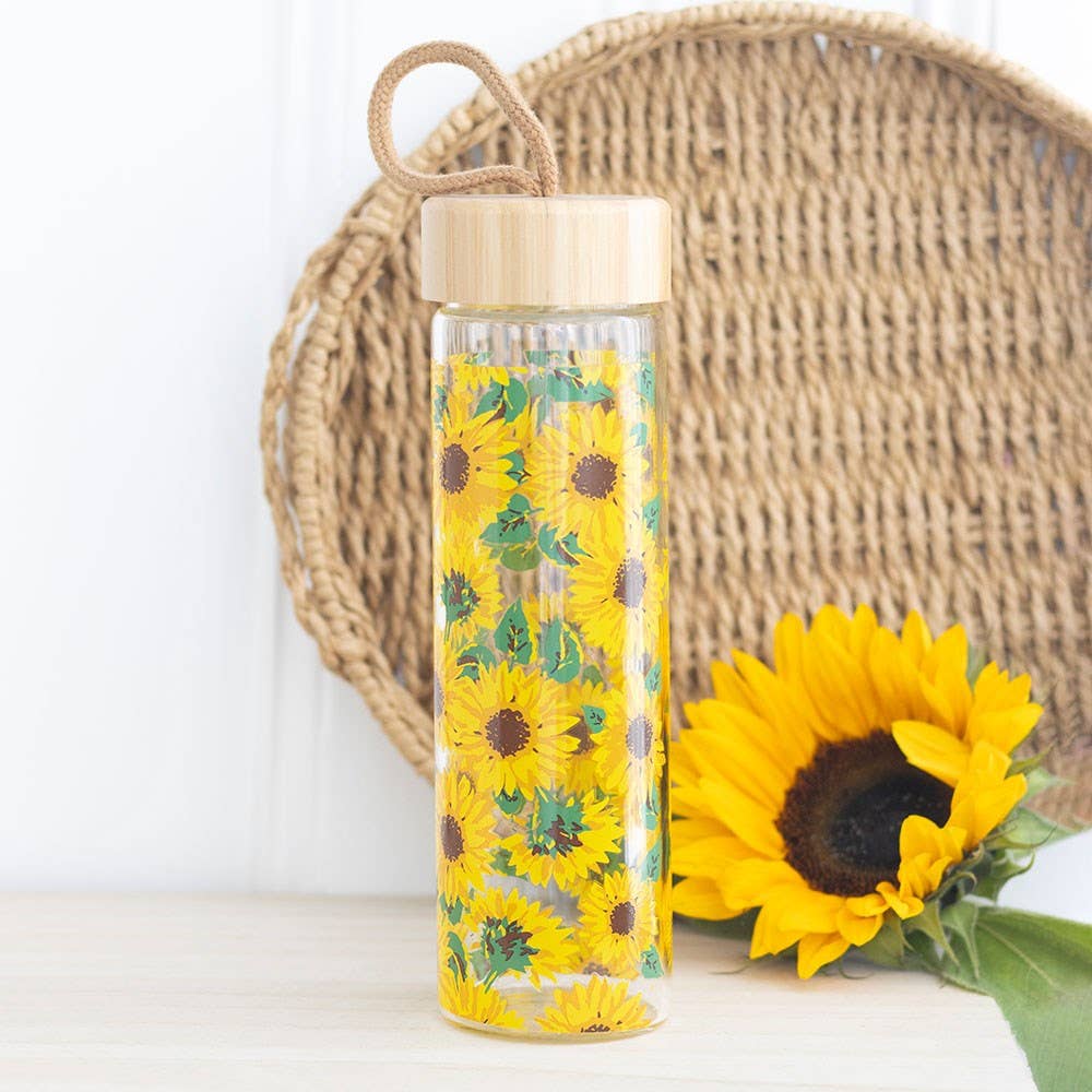 Glass water bottle with an all-over sunflower print, bamboo lid, and carrying loop.