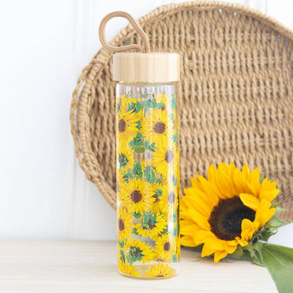 Glass water bottle with an all-over sunflower print, bamboo lid, and carrying loop.